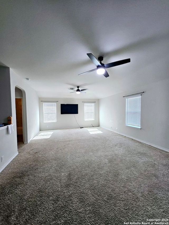 unfurnished living room featuring ceiling fan and carpet