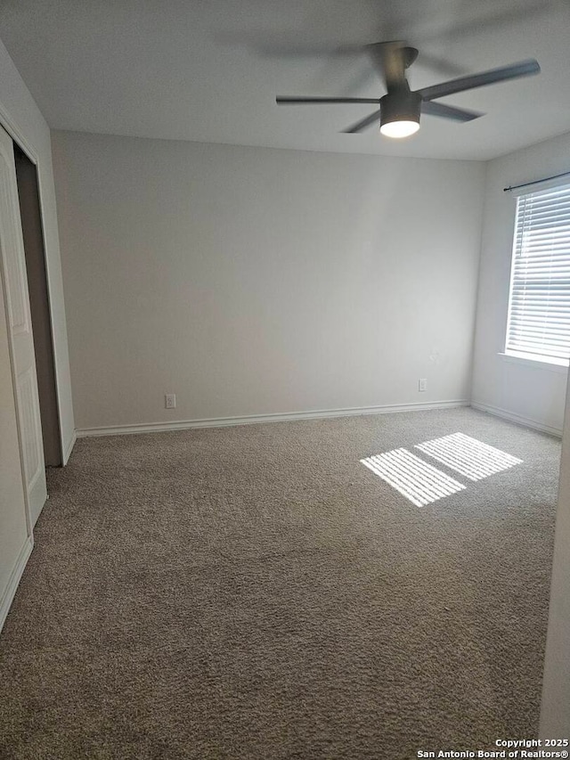 carpeted spare room with ceiling fan