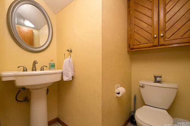 bathroom with a textured ceiling and toilet