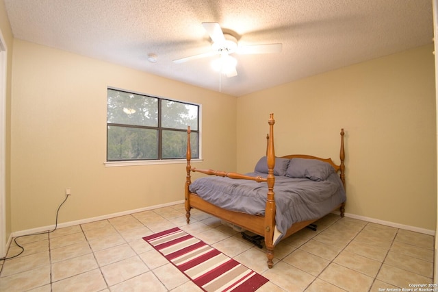 bedroom with a textured ceiling, ceiling fan, and light tile patterned floors