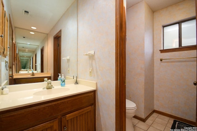 bathroom with toilet, tile patterned floors, and vanity