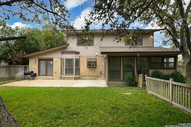 back of house featuring a lawn and a patio