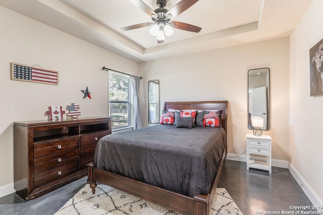 bedroom with ceiling fan and a raised ceiling