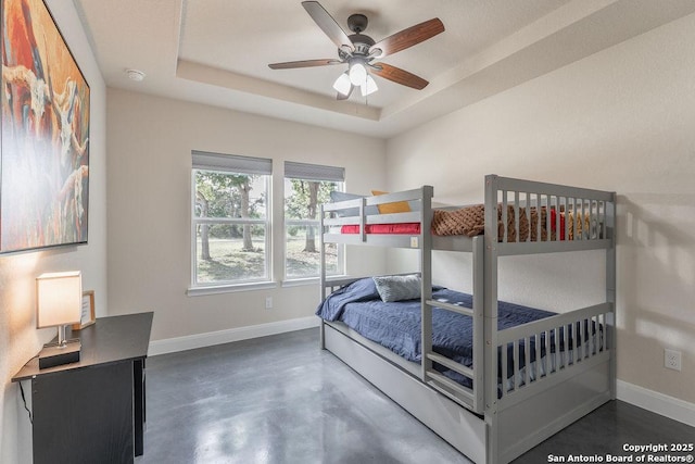 bedroom with ceiling fan and a raised ceiling