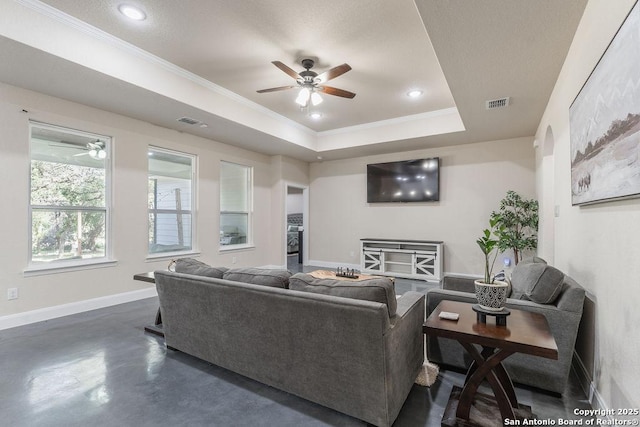 living room with a raised ceiling and ornamental molding