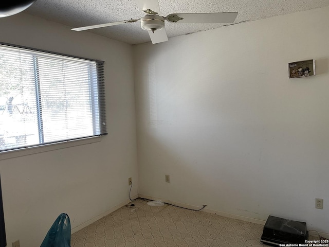 unfurnished room with ceiling fan, plenty of natural light, and a textured ceiling