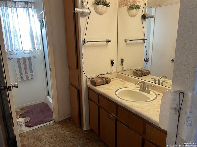 bathroom with a shower with shower door and vanity