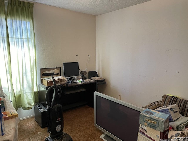 carpeted office space featuring a textured ceiling