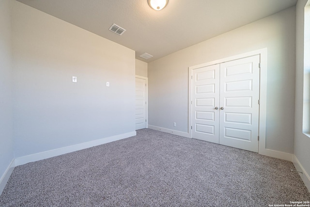 unfurnished bedroom with carpet and a closet