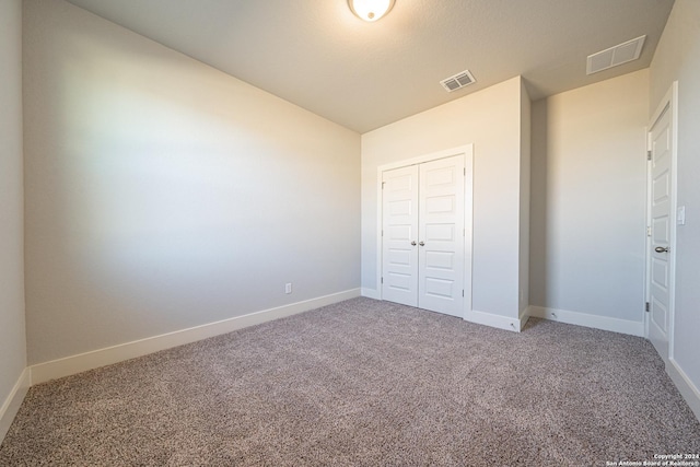 unfurnished bedroom featuring carpet and a closet