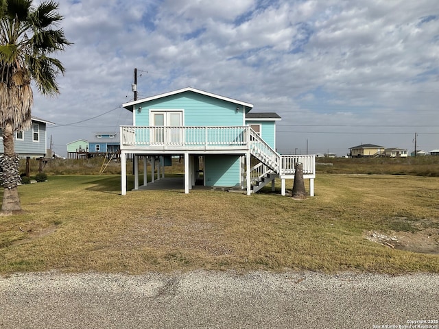 exterior space featuring a deck, a lawn, and a carport