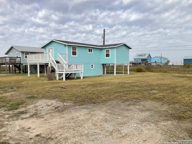 rear view of house with a wooden deck and a yard