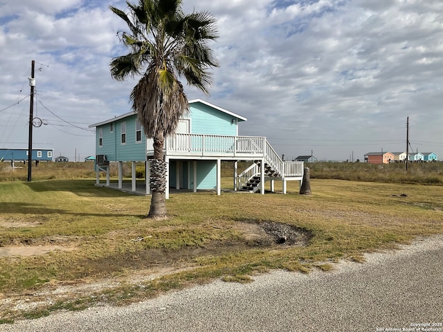 view of home's exterior with a deck, a lawn, and a carport