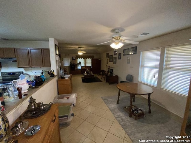 kitchen with light tile patterned floors, stainless steel range with electric stovetop, and ceiling fan