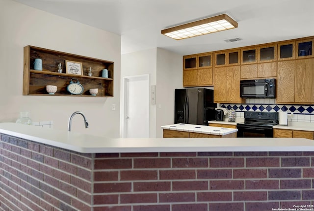 kitchen featuring sink, decorative backsplash, kitchen peninsula, and black appliances