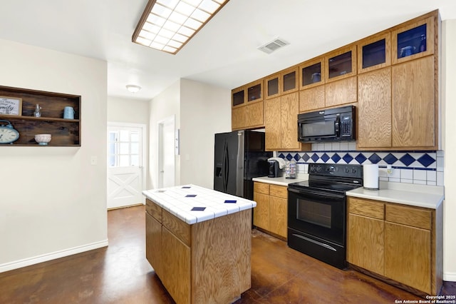 kitchen with black appliances, decorative backsplash, tile counters, and a kitchen island