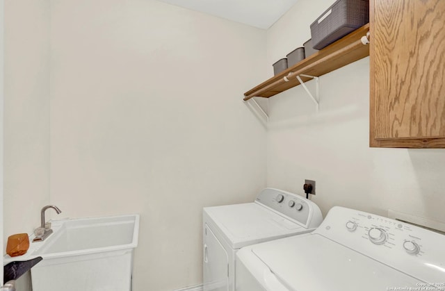 laundry room with cabinets, washer and clothes dryer, and sink