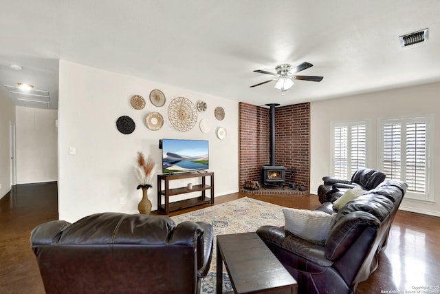 living room featuring ceiling fan and a wood stove