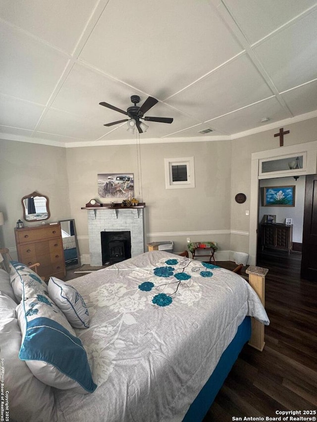 bedroom featuring ceiling fan, a wood stove, and dark hardwood / wood-style flooring