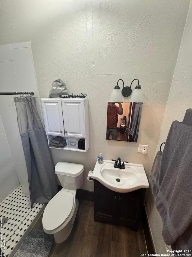 bathroom featuring toilet, vanity, a shower with curtain, and hardwood / wood-style floors