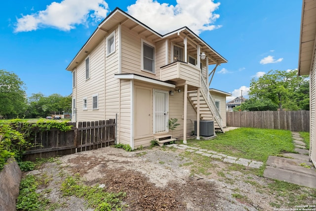 back of house featuring stairs, fence, a balcony, and cooling unit