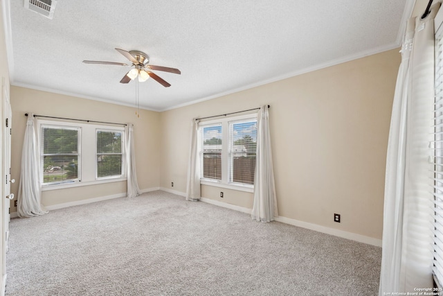spare room with visible vents, crown molding, carpet, and ceiling fan