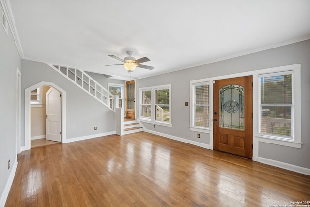 foyer featuring a ceiling fan, baseboards, ornamental molding, and hardwood / wood-style floors