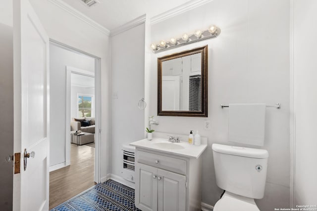 bathroom with vanity, toilet, baseboards, visible vents, and ornamental molding