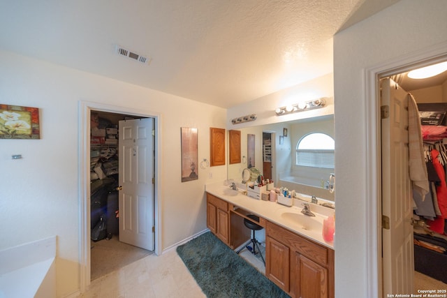 bathroom with a tub and vanity