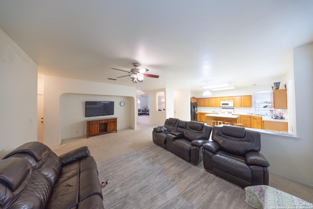 carpeted living room featuring ceiling fan