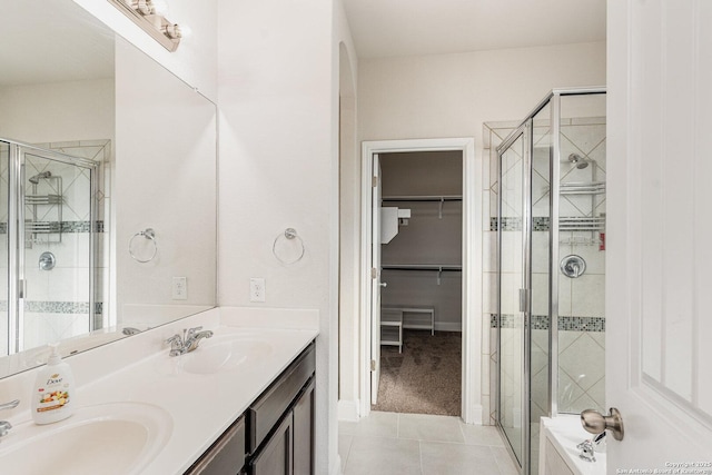 bathroom featuring walk in shower, vanity, and tile patterned flooring