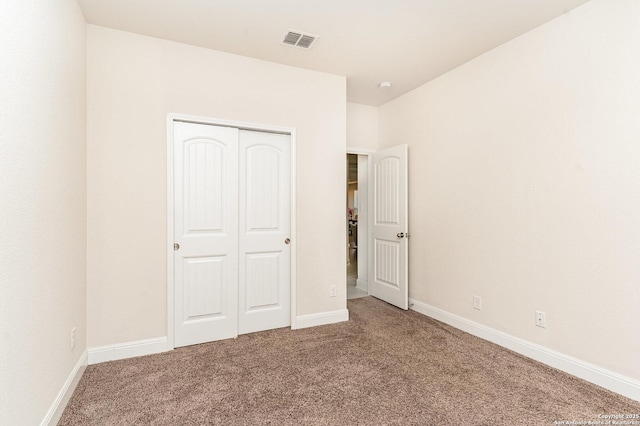 unfurnished bedroom with a closet and carpet flooring