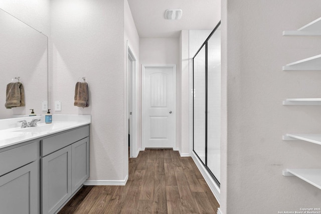 bathroom featuring walk in shower, vanity, and hardwood / wood-style flooring