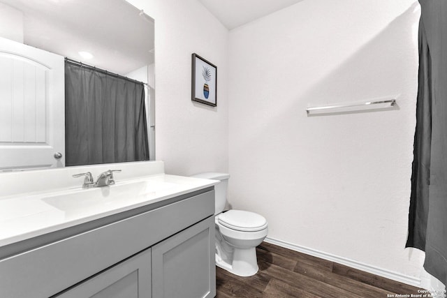 bathroom with wood-type flooring, toilet, and vanity