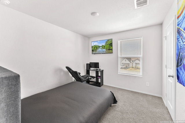 bedroom with light carpet and a textured ceiling