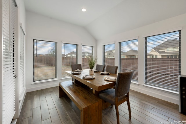 dining space with a healthy amount of sunlight, lofted ceiling, and dark hardwood / wood-style floors