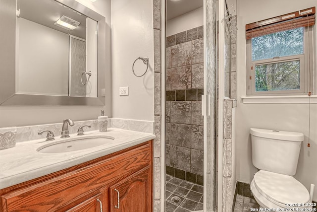 bathroom featuring toilet, vanity, and a tile shower