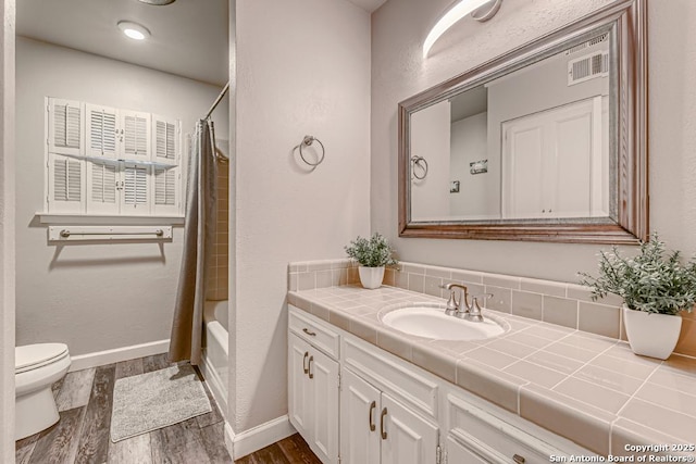 full bathroom with shower / bath combo with shower curtain, hardwood / wood-style floors, toilet, and vanity