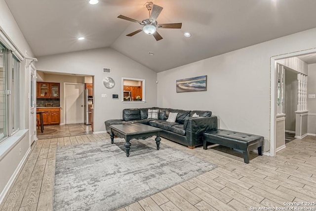 living room featuring vaulted ceiling and ceiling fan