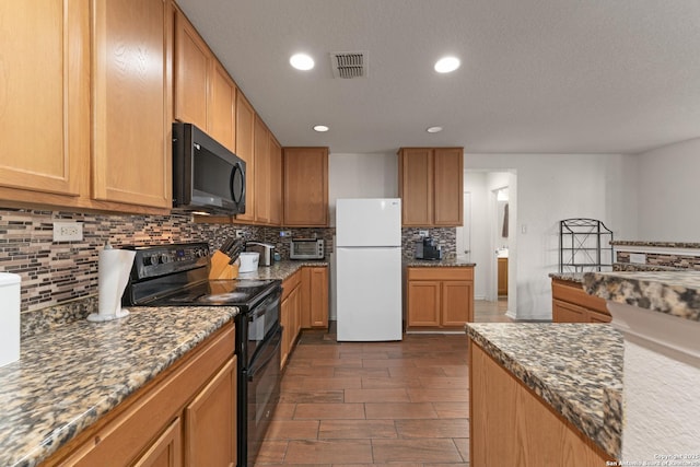 kitchen featuring decorative backsplash, a textured ceiling, black appliances, and dark stone countertops