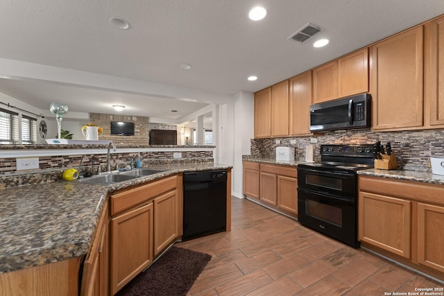 kitchen with sink, dark stone countertops, tasteful backsplash, and black appliances