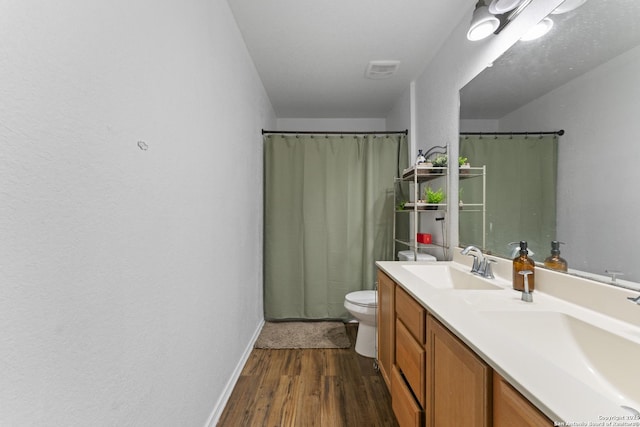 bathroom with hardwood / wood-style flooring, toilet, and vanity