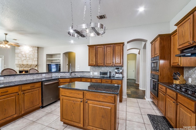 kitchen with sink, tasteful backsplash, a center island, a textured ceiling, and black appliances