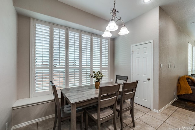 tiled dining room featuring plenty of natural light and a notable chandelier