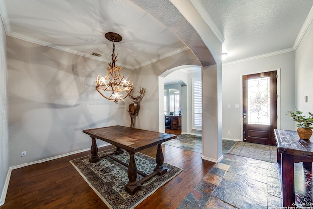 foyer with crown molding, dark hardwood / wood-style floors, a chandelier, and a textured ceiling