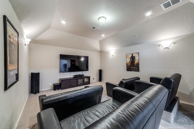 carpeted home theater room featuring lofted ceiling and a textured ceiling