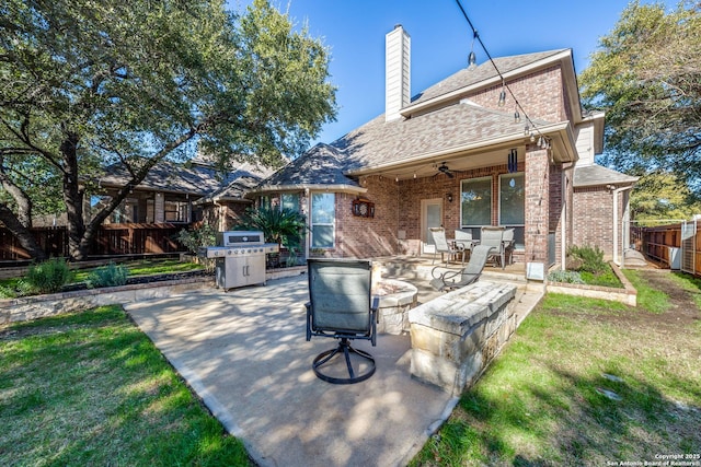 rear view of house with ceiling fan, a yard, and a patio area