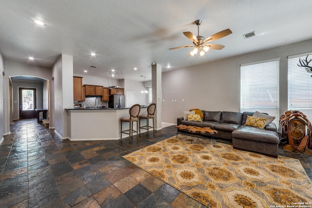 living room featuring a textured ceiling and ceiling fan