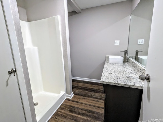 bathroom featuring walk in shower, hardwood / wood-style floors, and vanity