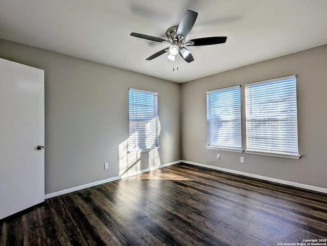 empty room with ceiling fan and dark hardwood / wood-style floors